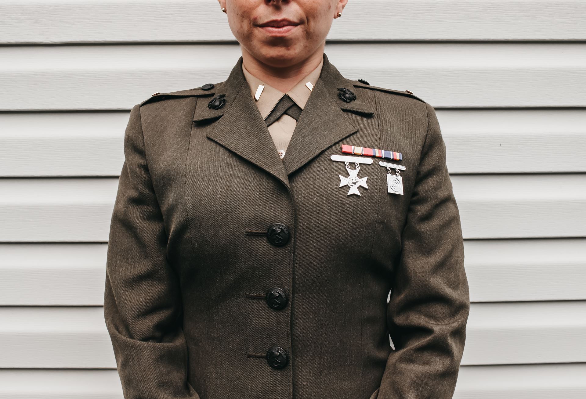 A woman standing to attention displaying her two war medals